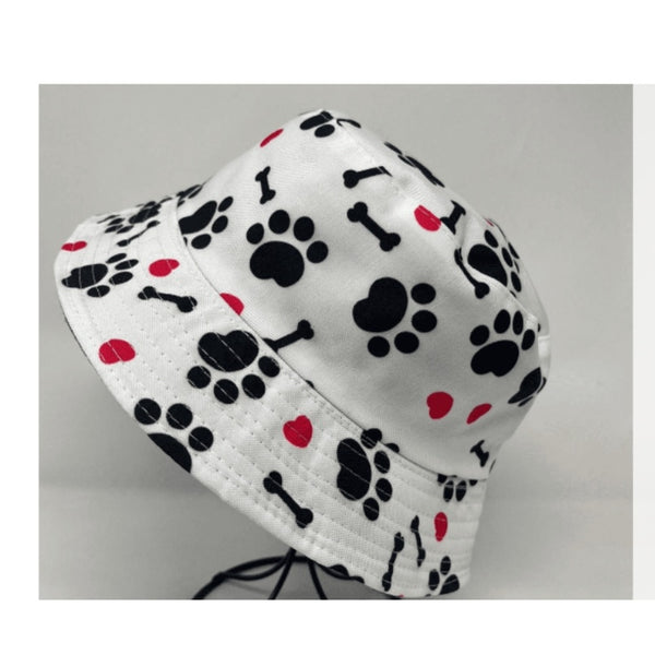 Black paw print & bones on a white bucket hat with red hearts.